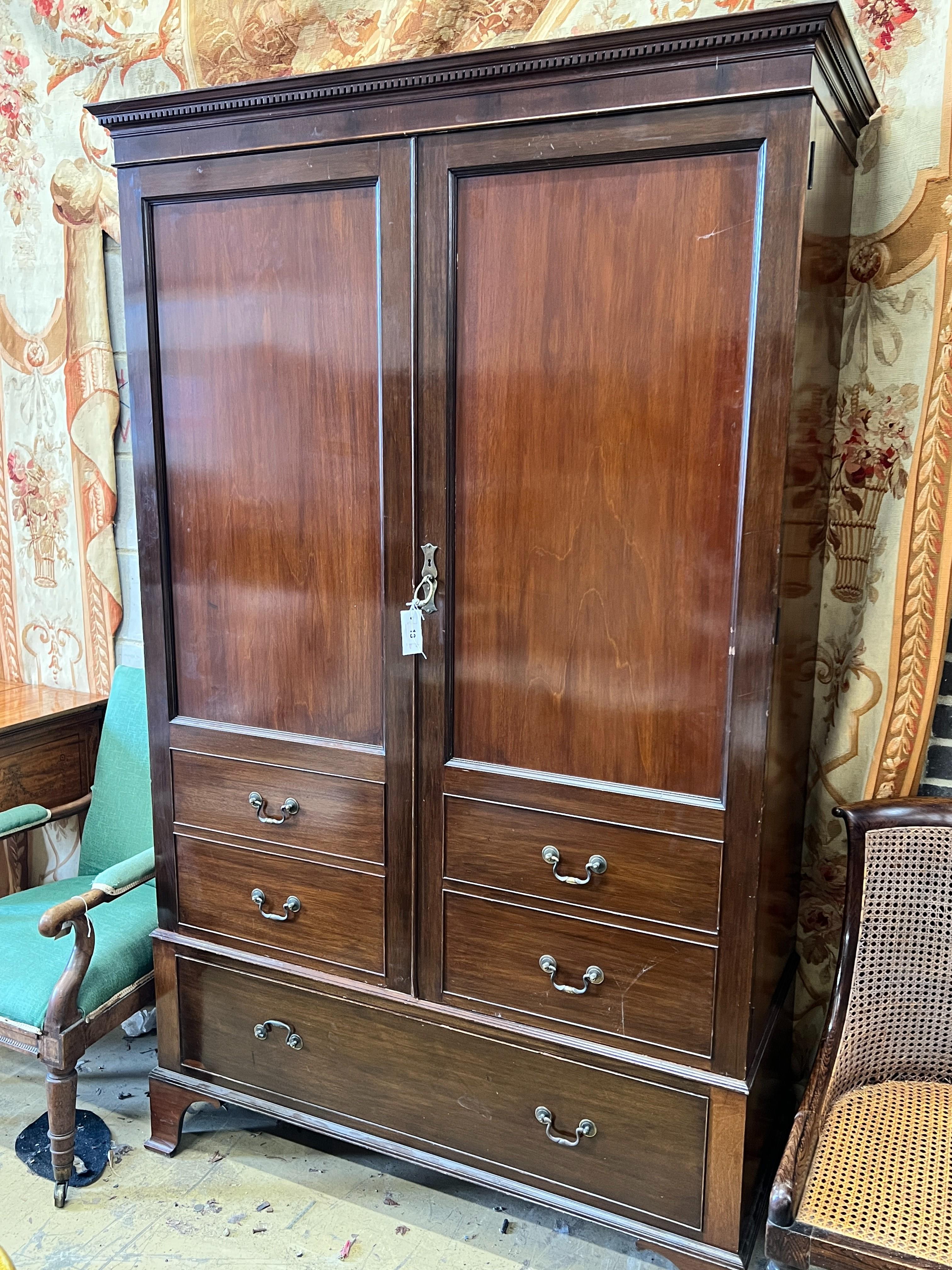 A 1920's mahogany press cupboard with part dummy drawer front over a single drawer, width 120cm, depth 50cm, height 196cm